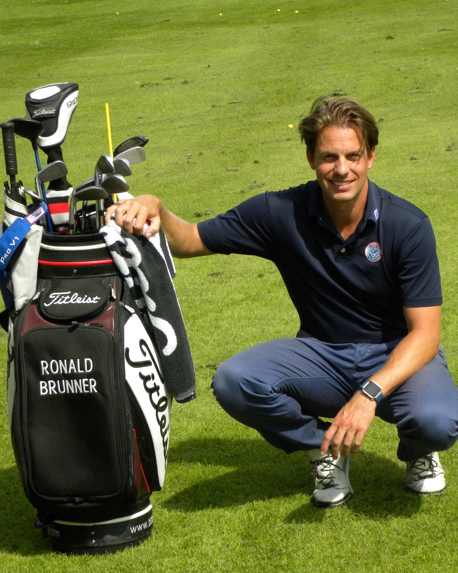 Ronald Brunner zit gehurkt naast zijn golftas op de fairway